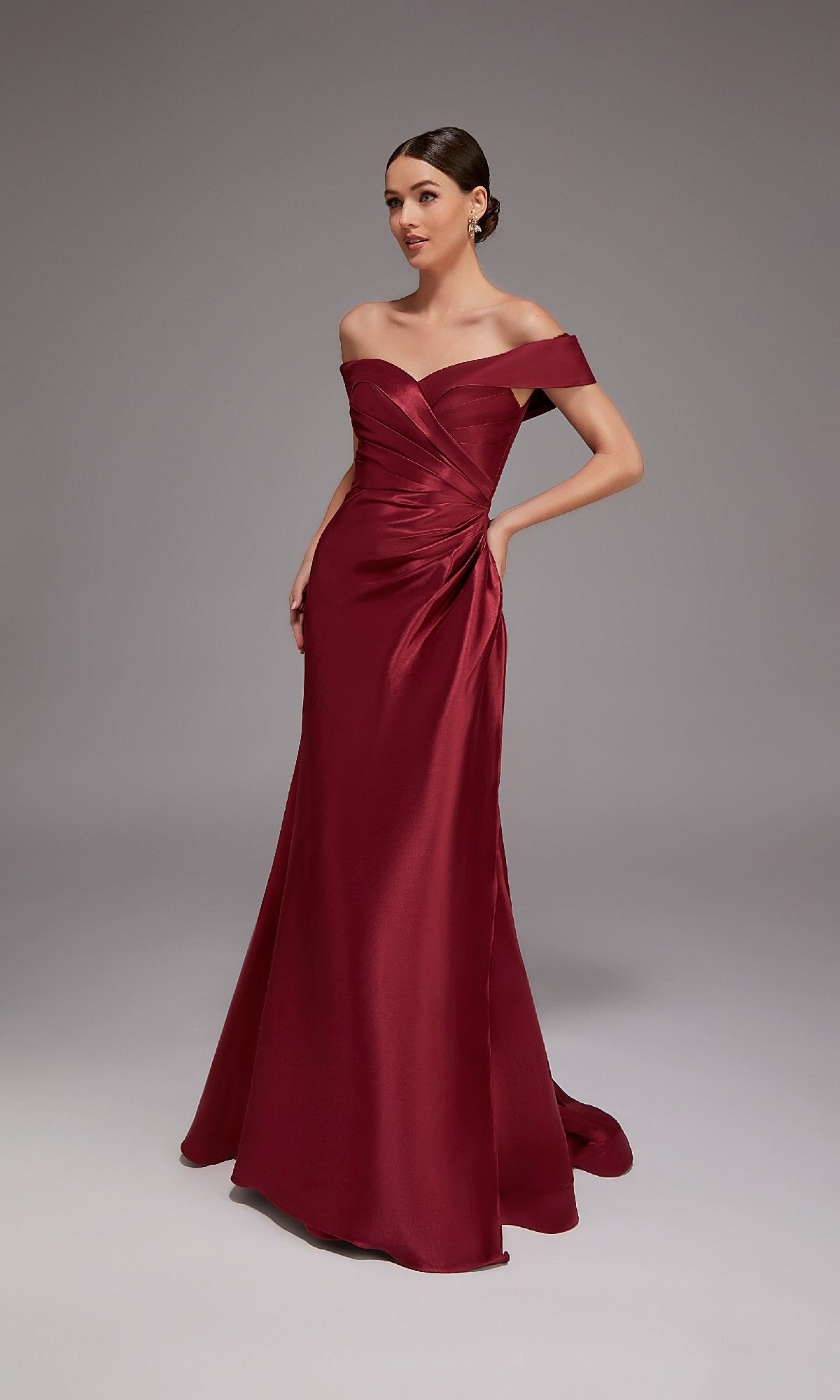 A woman wearing the Alyce 27857 long formal dress stands against a plain gray background with her hands at her sides.